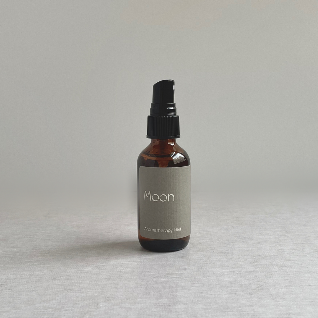 Species by the Thousands Moon Aromatherapy Mist in an amber glass bottle with gray label.