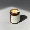 Species by the Thousands Fire Elemental Magic Candle in an amber jar with beige minimal paper label.