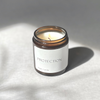 Species by the Thousands Protection Magic Candle in an amber jar with a minimal white paper label.